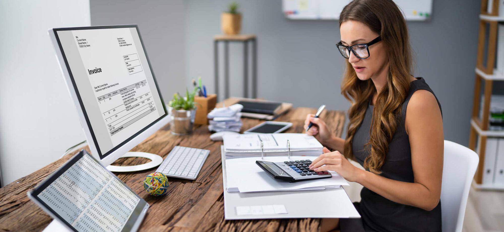 An accountant reviewing invoices and records at her desk
